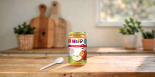 HiPP Bio Fruchtpüree Pfirsich in Apfel 250g im Vorteils-Glas auf Holztisch mit Löffel in heller Küchenumgebung