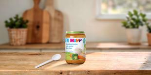 HiPP Gemüserisotto mit zarter Bio-Pute 220g im Glas mit Löffel auf Holztisch in heller, gemütlicher Küche