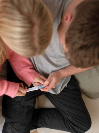 Expecting couple holding pregnancy test
