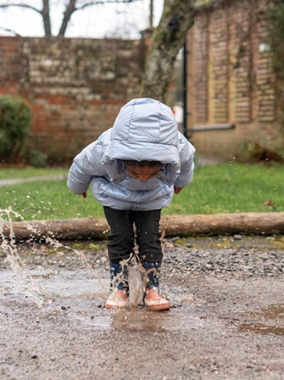 Toddler jumping in puddle