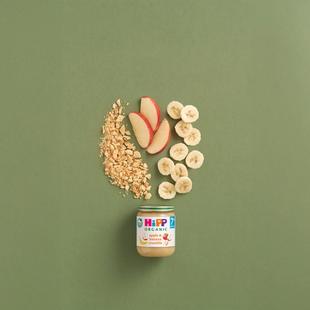 HiPP Organic Apple & Banana Crumble jar with apple and banana slices and biscuit crumble on a green background