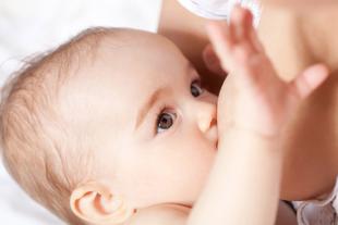 Nahaufnahme eines Babygesichts mit Schwerpunkt auf den Augen und dem Akt des Stillens.