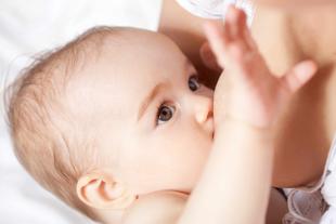 Nahaufnahme eines Babys, das an der Brust gestillt wird