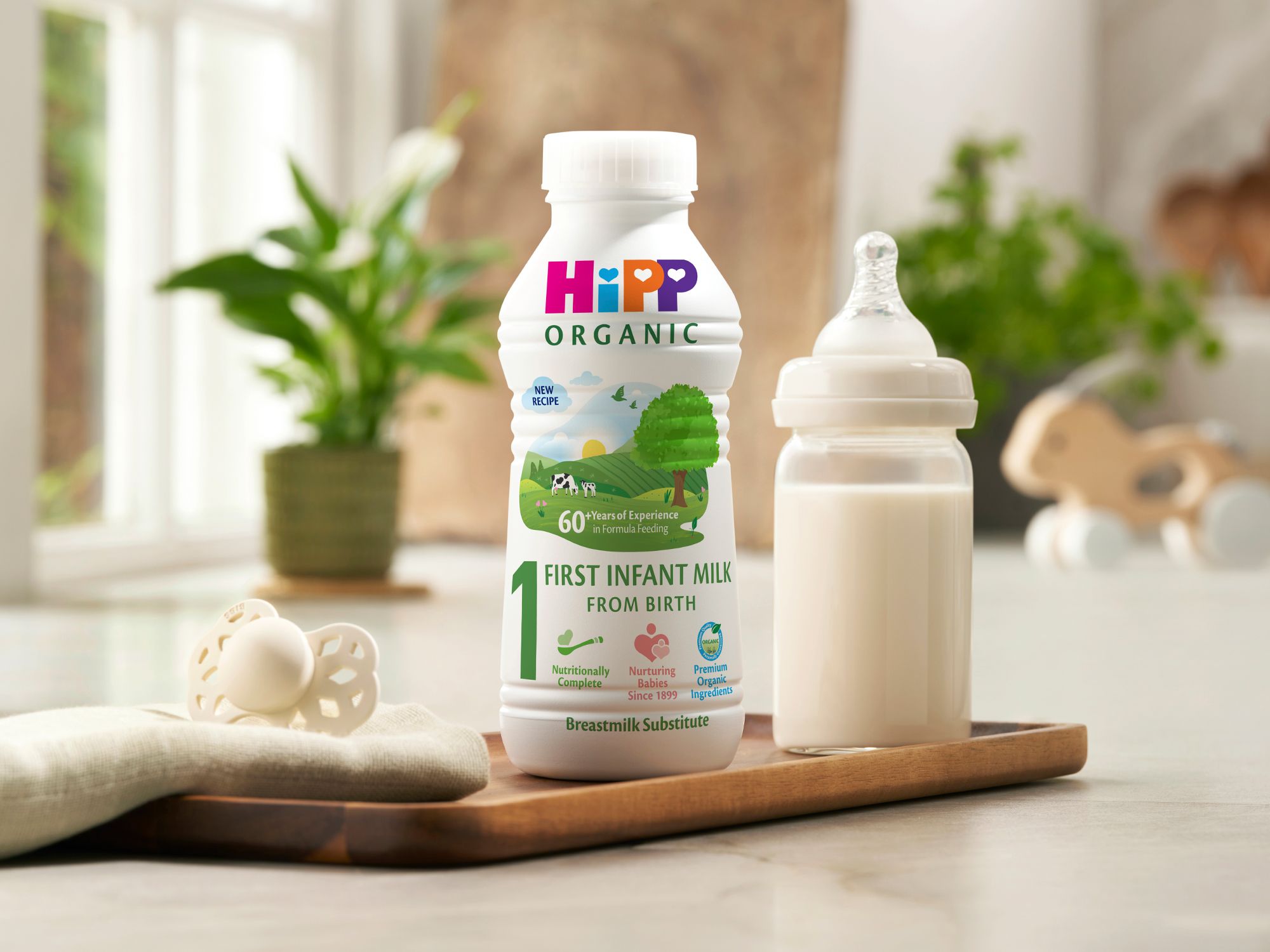 First infant milk ready to feed 470ml bottle next to a milk bottle on a kitchen worktop
