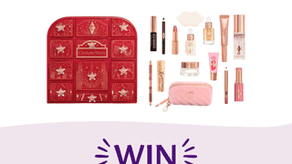 A Charlotte Tilbury beauty advent calendar in crimson red with gold details, displayed next to various makeup and skincare products and a pink quilted pouch, above large purple text that reads "WIN".