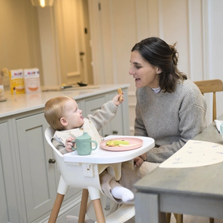 Dad encouraging baby to eat by herself