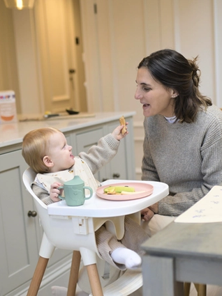 Dad encouraging baby to eat by herself