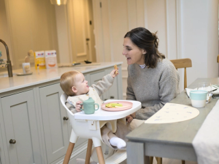 Dad encouraging baby to eat by herself