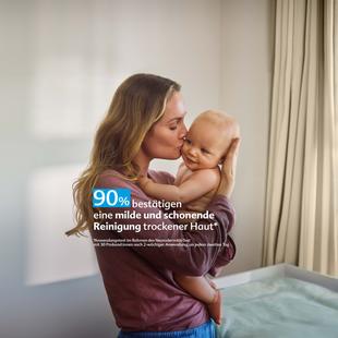 Mutter hält ihr Baby liebevoll im Arm und küsst es, daneben Text: „90 % bestätigen eine milde, schonende Reinigung trockener Haut“.