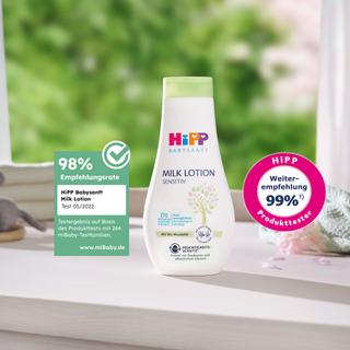 HiPP Babysanft Milk Lotion steht auf einem Wickeltisch, daneben Siegel mit 98 % Empfehlungsrate und 99 % Weiterempfehlung.