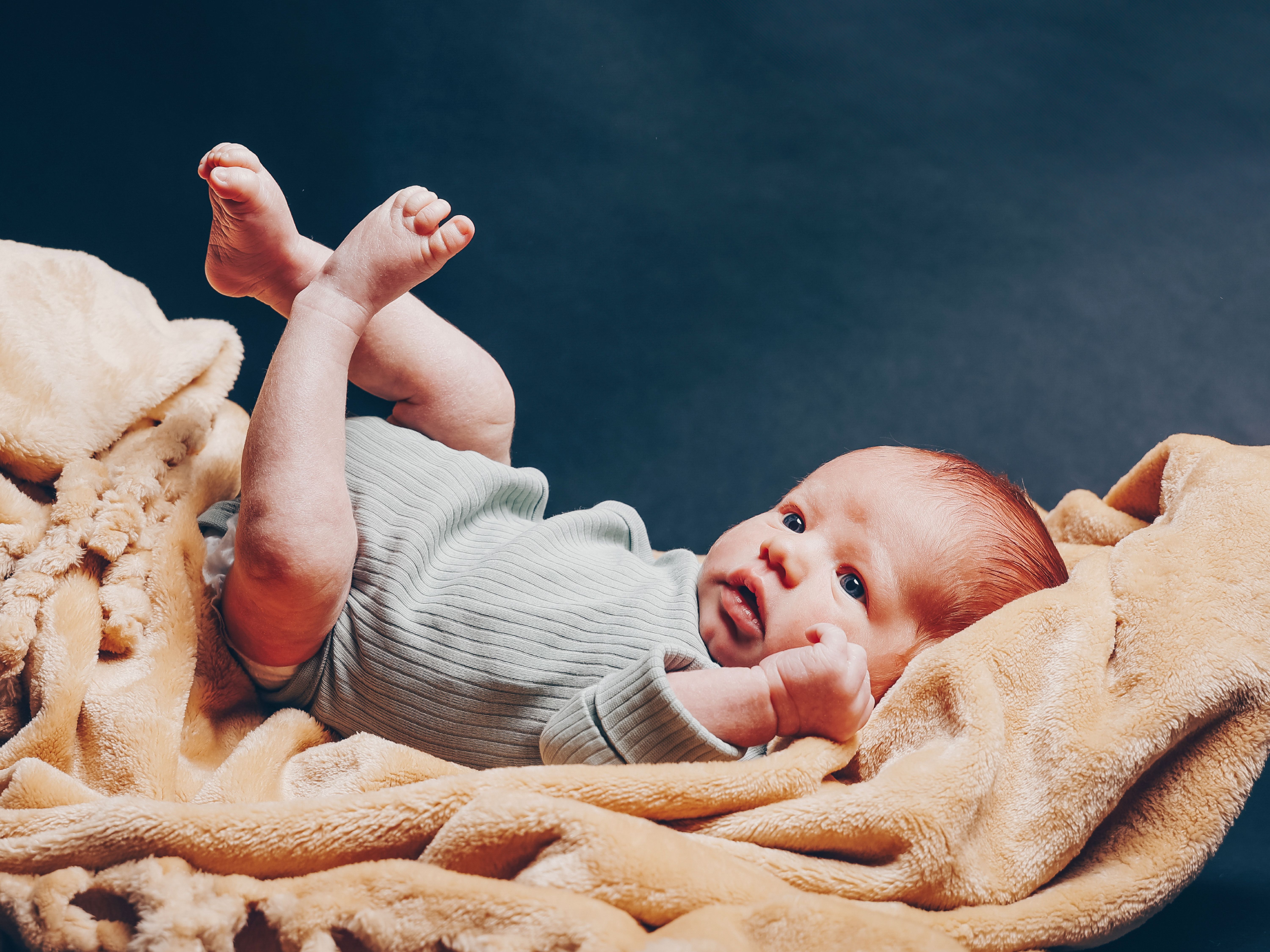 Baby liegt auf einer Decke
