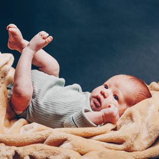 Baby liegt auf einer Decke