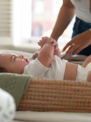 Mum changing baby on changing mat