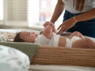 Mum changing baby on changing mat