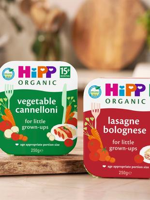 HiPP Organic 15+ months vegetable cannelloni and lasagne bolognese tray meals displayed on a cosy kitchen worktop.