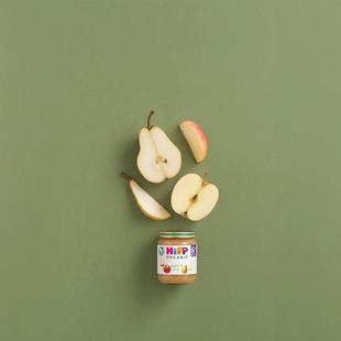 HiPP Organic Apple & Pear baby food jar with fresh apple and pear slices on a soft green background