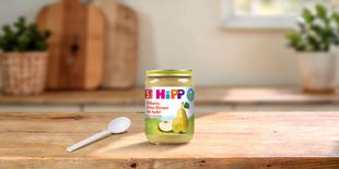 HiPP Bio Williams-Christ-Birnen mit Apfel 190g Babygläschen mit Löffel auf Holztisch in heller, gemütlicher Küche