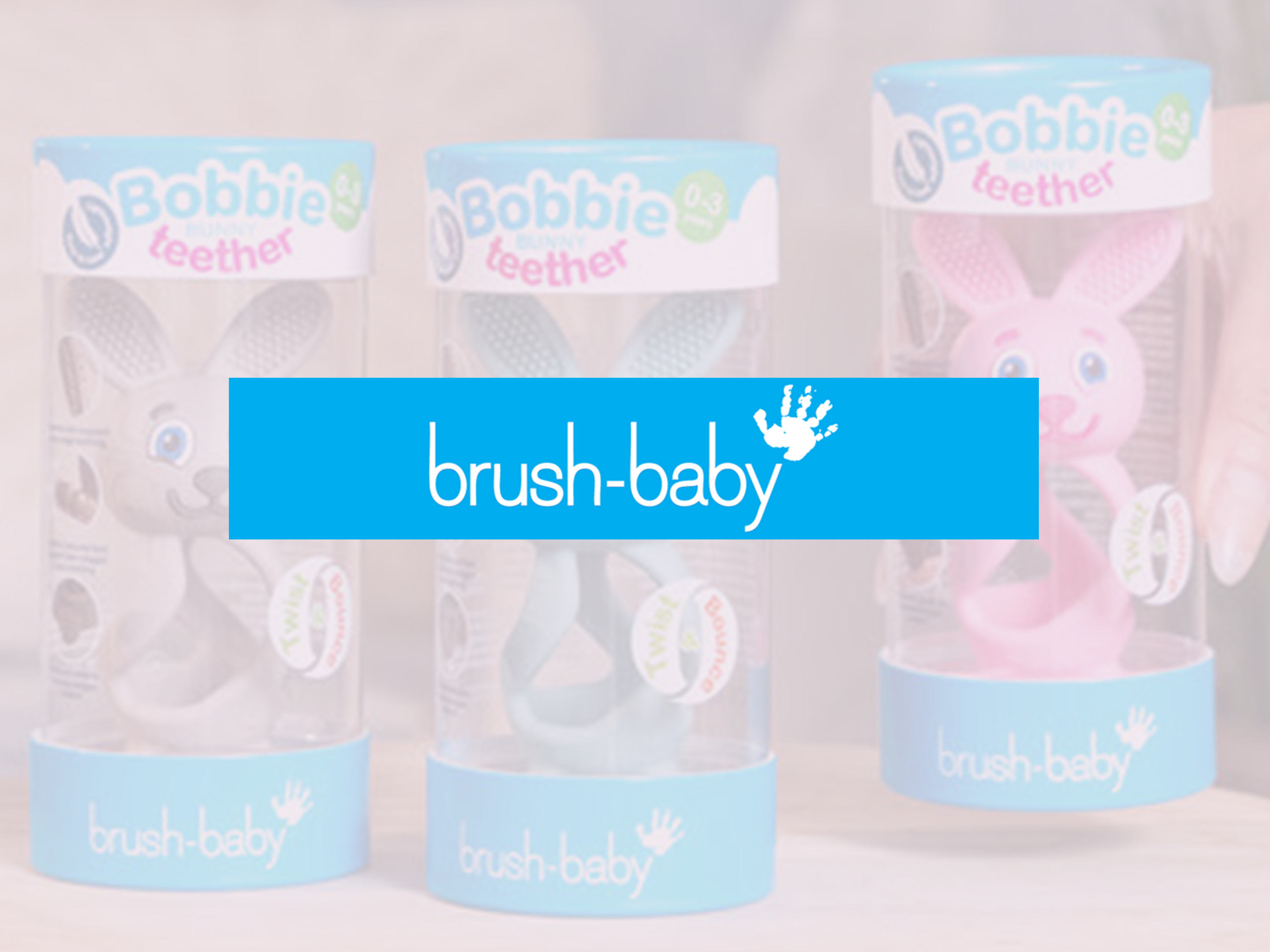 Brush-Baby Bobbie teether toys in colourful packaging with a bold blue Brush-Baby logo banner across the centre