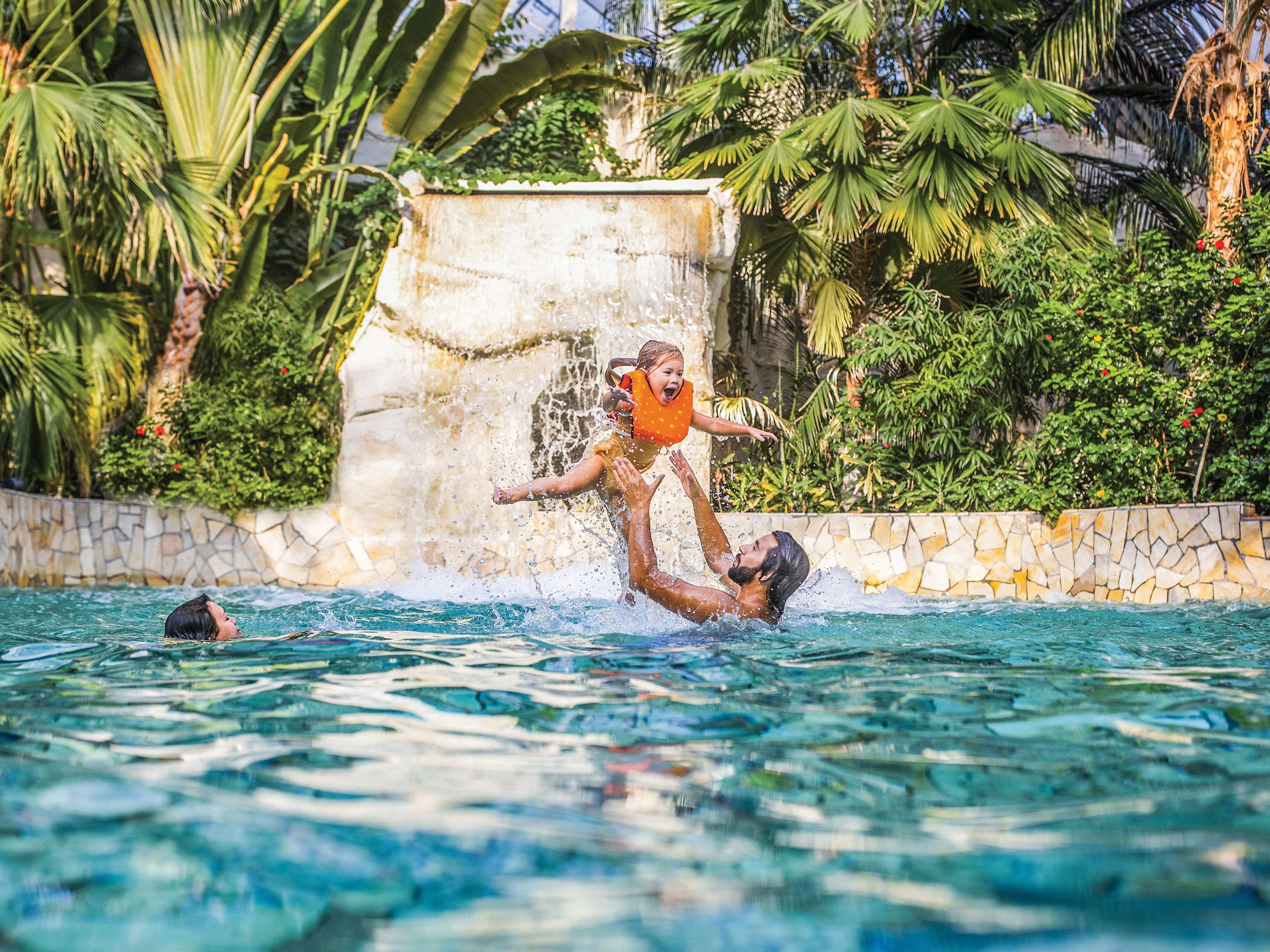 Familie im Wasser, Vater wirft Kind in die Luft