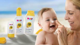 Ein Baby, das mit der Hand einer Frau Sonnenschutzmittel aufträgt, begleitet von verschiedenen Sonnenschutzmitteln mit LSF-Werten.