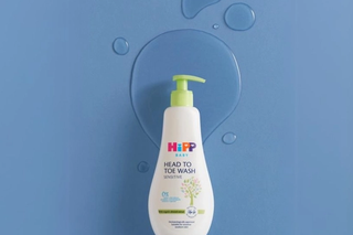 HiPP Head to toe baby wash on a shelf over a bath next to a bath towel