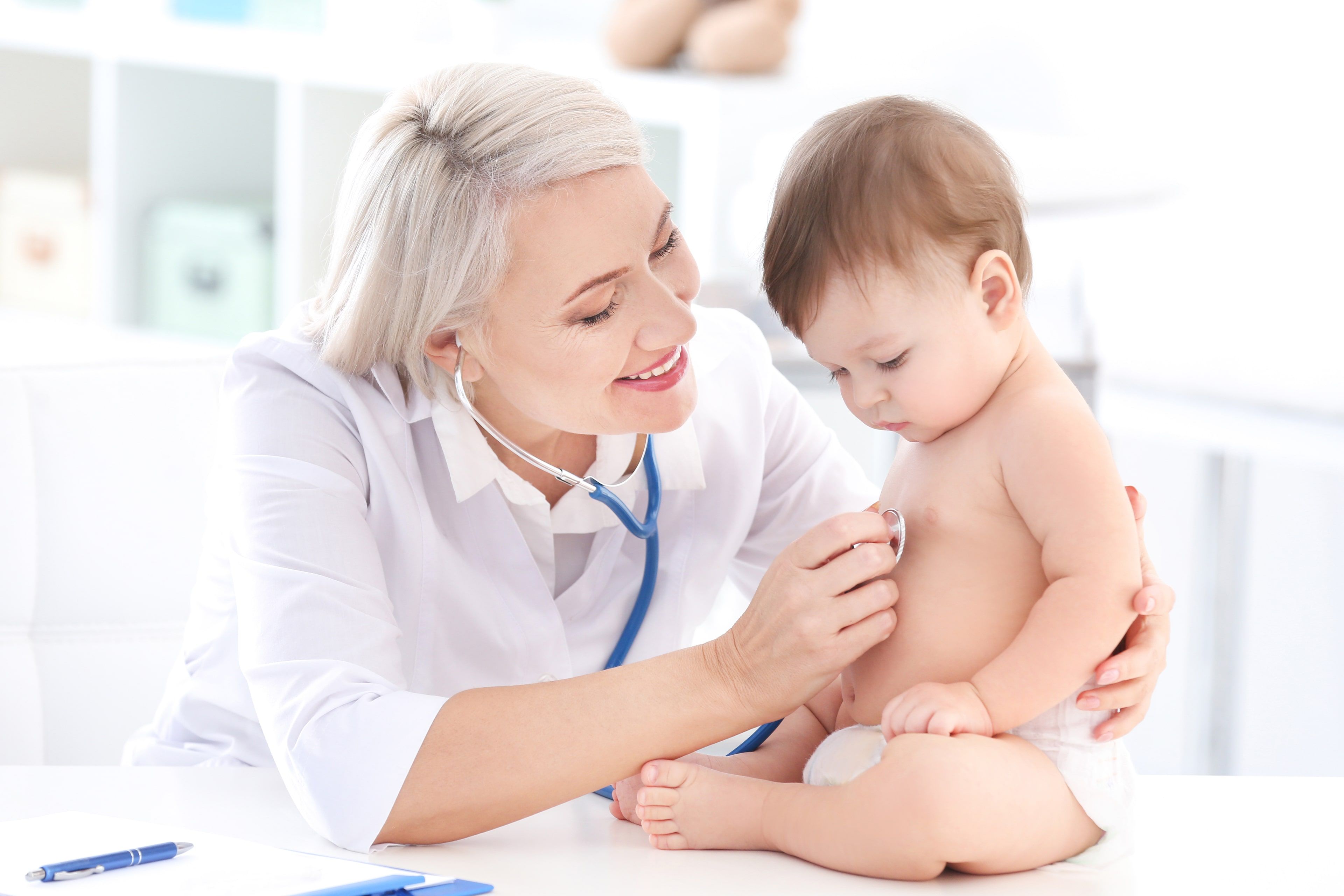 Eine medizinische Fachkraft, die ein Baby in einer klinischen Umgebung betreut.