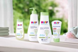 HiPP Babysanft Sensitiv Pflegeöl, Waschgel, Milk Lotion und Pflegecreme mit Bio-Mandelöl stehen vor unscharfem, grünem Naturhintergrund.