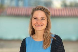 Katharina, lächelnde Wissenschaftlerin im HiPP Muttermilchforschungsteam, im Porträt vor unscharfem Hintergrund