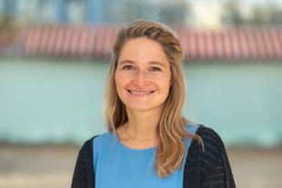 Katharina, lächelnde Wissenschaftlerin im HiPP Muttermilchforschungsteam, im Porträt vor unscharfem Hintergrund