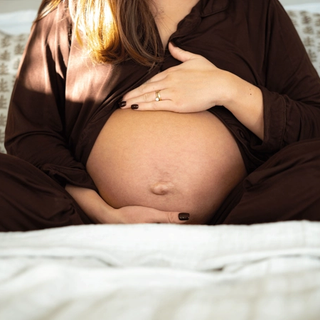Expecting mother massaging her bump