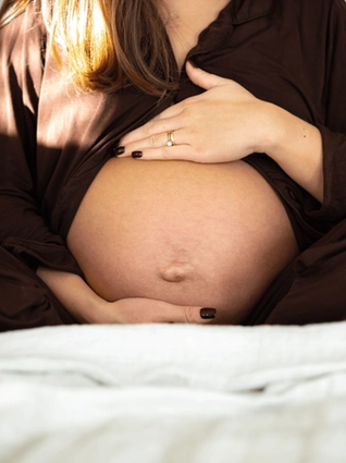 Expecting mother massaging her bump