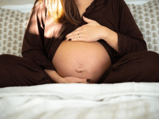 Expecting mother massaging her bump