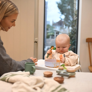 Baby looking at piece of carrot