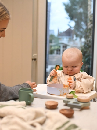 Baby looking at piece of carrot