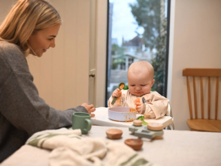 Baby looking at piece of carrot