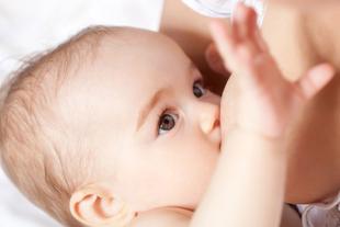 Nahaufnahme eines Babygesichts mit Schwerpunkt auf den Augen und dem Akt des Stillens.