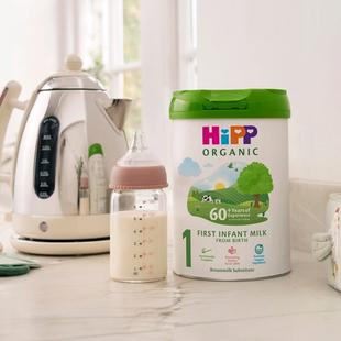 HiPP Organic First Infant Milk Powder Tin on a kitchen worktop next to a bottle of milk