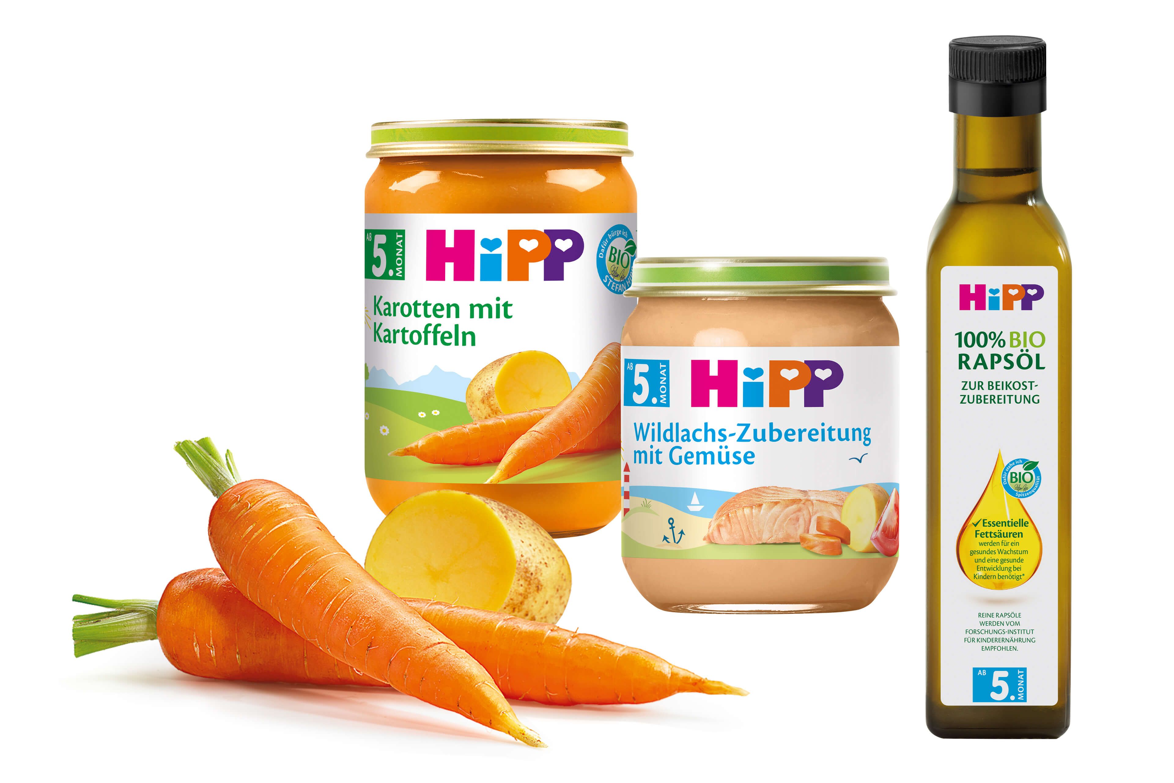 Eine Reihe von Babynahrungsprodukten der Marke "Hipp", darunter Gläser mit Karotten- und Orangenpüree und eine Flasche Olivenöl.