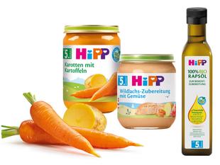 Eine Reihe von Babynahrungsprodukten der Marke "Hipp", darunter Gläser mit Karotten- und Orangenpüree und eine Flasche Olivenöl.
