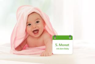 Lachendes fünf Monate altes Baby liegt unter rosa Handtuch, daneben ein Kalenderfeld mit Text „5. Monat mit dem Baby“.
