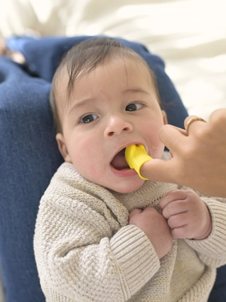 Mum brushing babies teeth