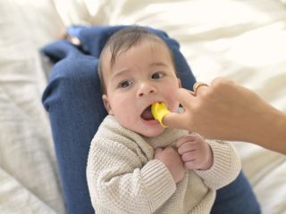 Mum brushing babies teeth