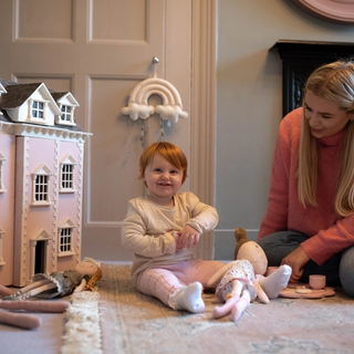 Mum and daughter playing with dolls and dollhouse