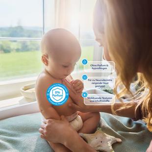 Mutter hält Baby auf dem Schoß vor einem Fenster mit drei blauen Textboxen, die Eigenschaften eines Produkts beschreiben