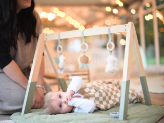 Baby on a play mat chewing on his fingers