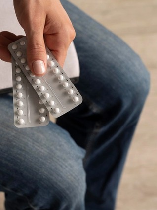 Woman holding packs of contraceptive pills