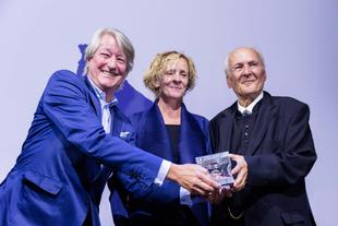 Christian DuMont Schütte und Isabella Neven DuMont überreichen Prof. Dr. Claus Hipp den Award „Lichtgestalt Wirtschaft“ auf der Bühne.