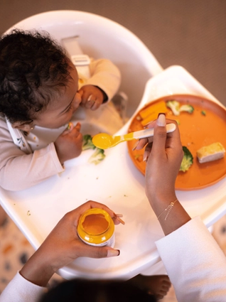 Baby eating at highchair