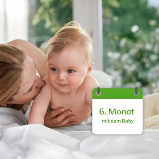 Eine Mutter, die liebevoll mit ihrem 6 Monate alten Baby umgeht, mit einem grünen Banner im Hintergrund, auf dem der Text "6. Monat mit dem Baby".