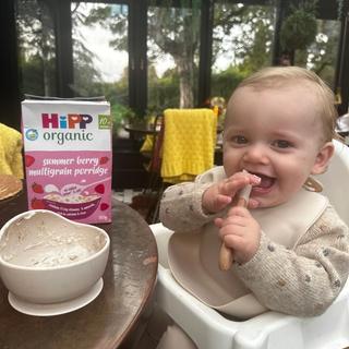 Baby boy eating a bowl of HiPP Organic summer berry multigrain porridge